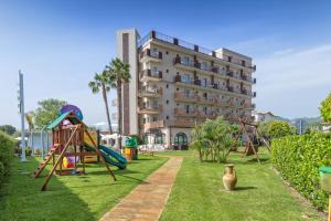 un parco giochi di fronte a un grande edificio di Almaluna Hotel & Resort ad Alba Adriatica