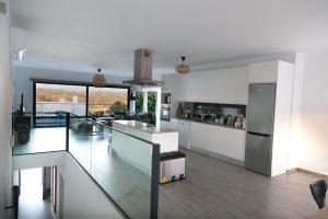 a kitchen with white walls and a glass floor at Cairnvillas - Le Maquis C34 Luxury Villa with Private Pool near Beach in Aljezur