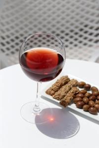 Casabella في ناكسوس تشورا: كوب من النبيذ الأحمر بجوار طبق من الكعك