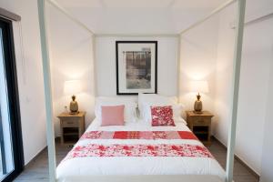 a bedroom with a large white bed with red pillows at Cairnvillas - Le Maquis C34 Luxury Villa with Private Pool near Beach in Aljezur
