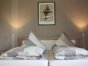 a bed with two pillows and a picture on the wall at Ferienwohnung Biederbick in Diemelsee