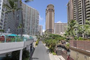 eine Straße in einer Stadt mit Palmen und Gebäuden in der Unterkunft Harbor View Plaza #1203 in Honolulu