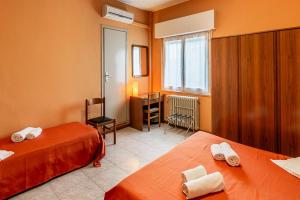 a hotel room with two beds and a desk at Hotel La Favorita in Peschiera del Garda
