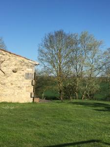 ein altes Steingebäude auf einem Feld mit Bäumen in der Unterkunft GITE DES CHOUETTES in Muron