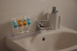un lavandino con rubinetto e spazzolini da denti di Grace Hotel & Studios a Sými