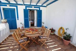 a patio with a table and chairs and blue doors at Katerina Rooms in Naousa