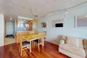 eine Küche und ein Wohnzimmer mit einem Tisch und einem Sofa in der Unterkunft Harbor View Plaza #1203 in Honolulu