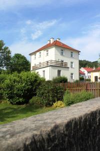 a white house with a fence in front of it at Apartmány U Mariánské kaple in Česká Kamenice