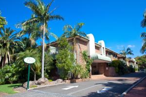 ウーロンゴンにあるThe Belmore Apartments Hotelの通路脇時計付きの建物