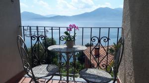 una mesa y sillas en un balcón con vistas al océano en Hotel Sole en Cannero Riviera
