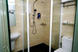 uma casa de banho com um chuveiro e um WC. em Alami Garden Hotel em Shah Alam