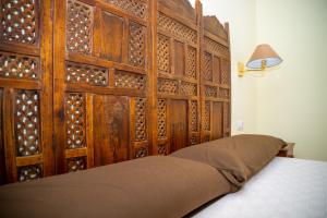 una camera con letto e testiera in legno di El Jasmine a Corralejo Altre 37 foto