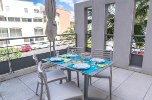 a table and chairs on a balcony with an umbrella at Résidence Thalacap in Cap d'Agde