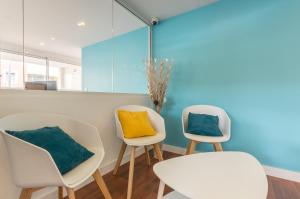 two white chairs with a yellow pillow on them in a room at Résidence Thalacap in Cap d'Agde
