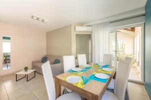 a dining room with a wooden table and chairs at Résidence Thalacap in Cap d'Agde
