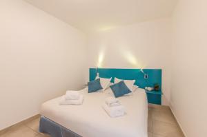 a bedroom with a large white bed with blue accents at Résidence Thalacap in Cap d'Agde +37 photos