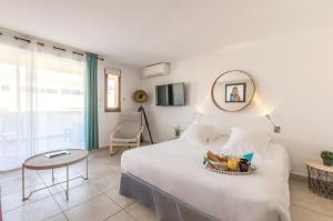 a bedroom with a bed with a table and a mirror at Résidence Thalacap in Cap d'Agde