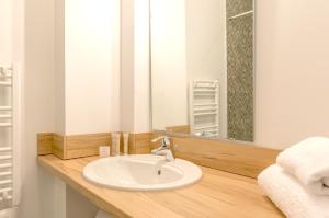 a bathroom with a sink and a mirror at Résidence Thalacap in Cap d'Agde