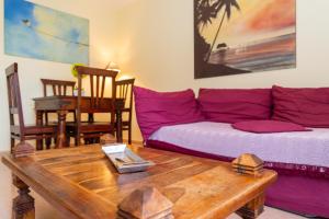 a living room with a purple couch and a wooden table at El Jasmine in Corralejo