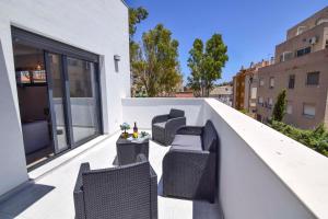 a balcony with two chairs and a table at Letmalaga Carlos Haya in Málaga
