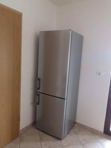 a stainless steel refrigerator in a corner of a room at Sobe SM0LEJ in Bled