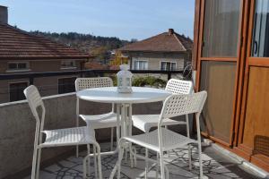 uma mesa branca e cadeiras numa varanda em Guest House Ganovi em Kalofer