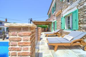 a stone house with a pool and a patio at Villa Stone Queen in Malinska
