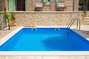 a swimming pool in a yard with a blue pool at Villa Stone Queen in Malinska