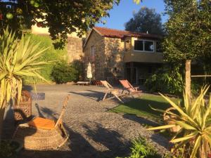 a yard with chairs and a house at Casa Magnólia in Braga