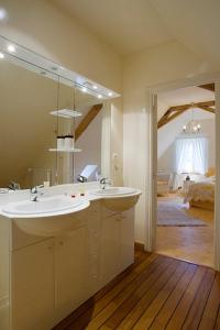uma casa de banho com 2 lavatórios e um espelho grande em La Tuilerie du Paligny em Tallud-Sainte-Gemme
