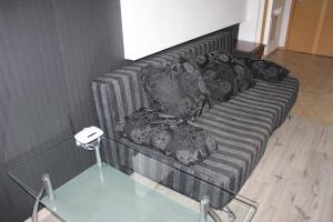 a couch with pillows and a glass table at City apart in Sofia