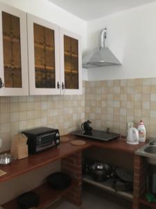 eine Küche mit weißen Schränken und einer Theke mit einer Mikrowelle in der Unterkunft Maly bialy domek pod brzozami in Nałęczów