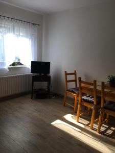 ein Wohnzimmer mit einem Stuhl, einem Tisch und einem Fenster in der Unterkunft Maly bialy domek pod brzozami in Nałęczów