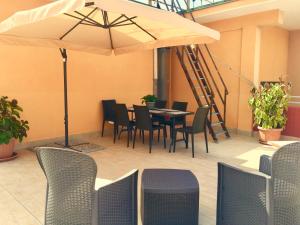 een patio met een tafel en stoelen en een parasol bij Dimora Montpellier in Salerno