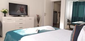 - une chambre avec un lit et une télévision sur une commode dans l'établissement Luxury-Apartment Ultracentral, à Câmpulung Moldovenesc