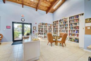 a library with a table and chairs and bookshelves at Beach Getaway - Ocean beach, tennis, golf, pool with tiki bar in Fort Pierce