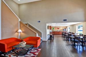 un vestíbulo con muebles rojos, mesas y sillas en Quality Inn & Suites Heritage Park, en Kissimmee