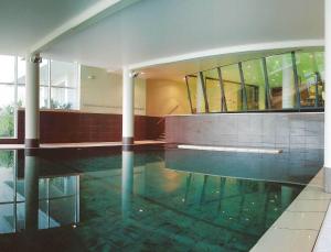 a swimming pool with water in a building at Alliance Pornic Hôtel Thalasso & Spa in Pornic