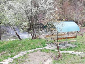 um banco de parque sentado ao lado de um rio em Вила Мирела em Ribarica