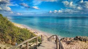 a wooden staircase leading to a beach with the ocean at B&B Lo Scrigno del Salento in Sava