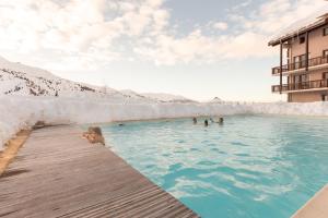 a group of people in a swimming pool at Residence Le Thabor - maeva Home in Valmeinier