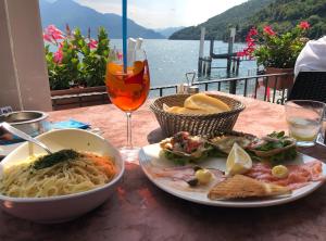 a table with a plate of pasta and a glass of wine at Luxury Apartment Lake Como in Acquaseria