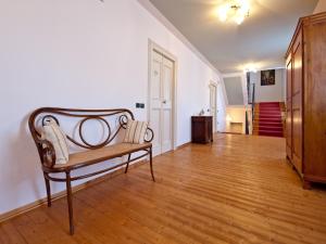 a living room with a bench and a wooden floor at Villa Butussi - L'ospitalità del Vino in Corno di Rosazzo