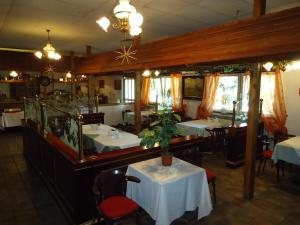 ein Speisesaal mit Tischen und Stühlen und ein Restaurant in der Unterkunft Hotel Ottersleben in Magdeburg