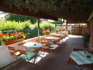 a patio area with tables, chairs and umbrellas at Hotel Ottersleben in Magdeburg