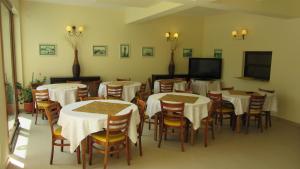 a dining room with tables and chairs and a flat screen tv at Vila Gente in Mamaia Sat/Năvodari