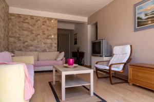 a living room with a couch and a tv at Starfish Villa in Iraklitsa