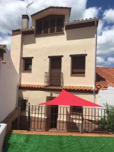 un edificio con una tienda roja delante de él en LA CASA DEL LILO, en Navamorcuende