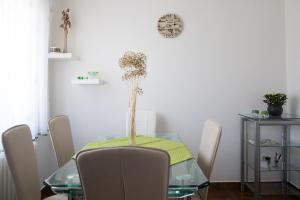 a dining room table with a vase of flowers on it at Daisy Family Appartment, Vrhnika near Ljubljana in Vrhnika