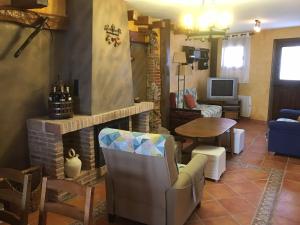 sala de estar con chimenea, mesa y sillas en LA CASA DEL LILO, en Navamorcuende